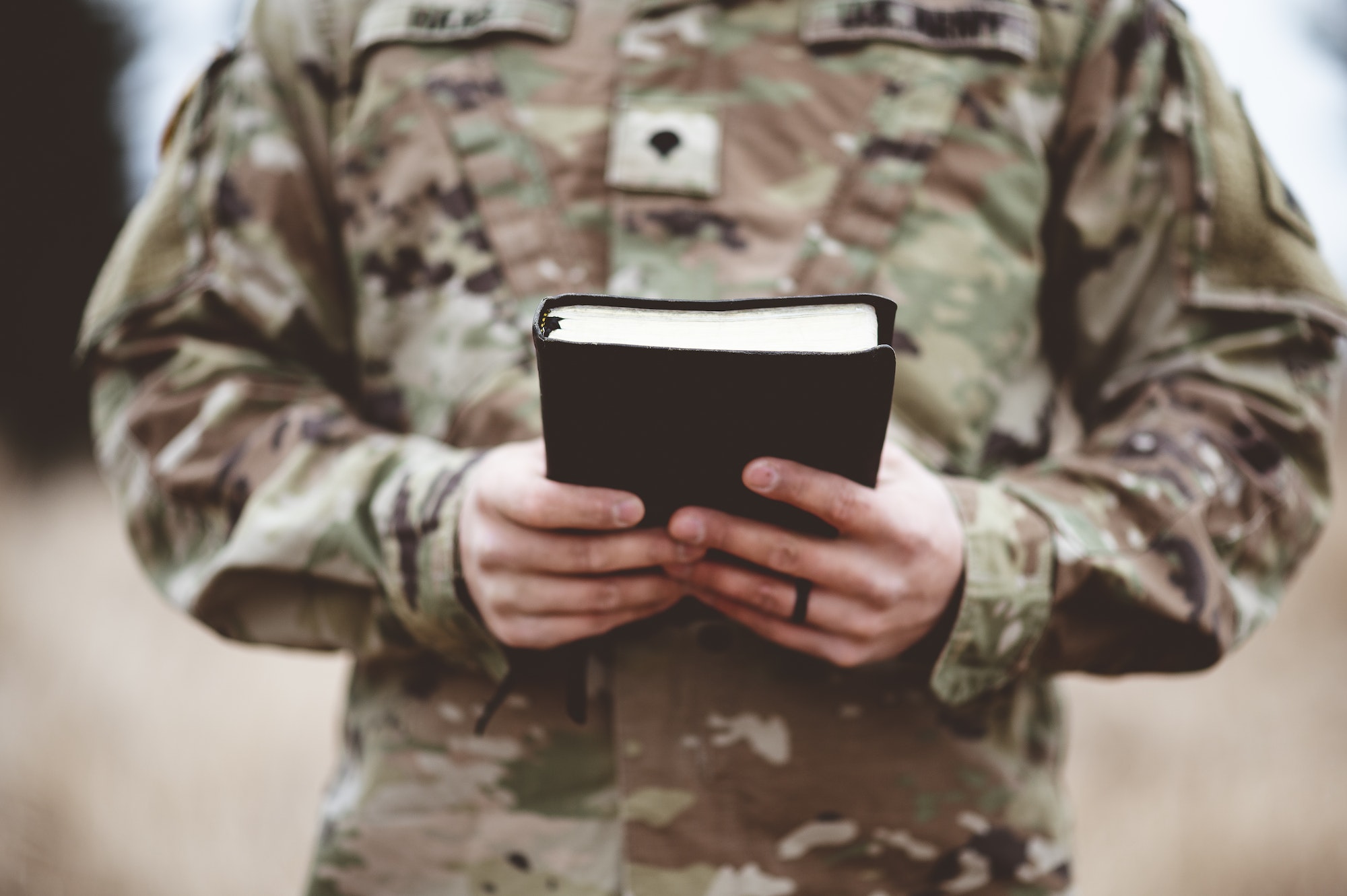 Shallow focus shot of a young soldier holding a bible